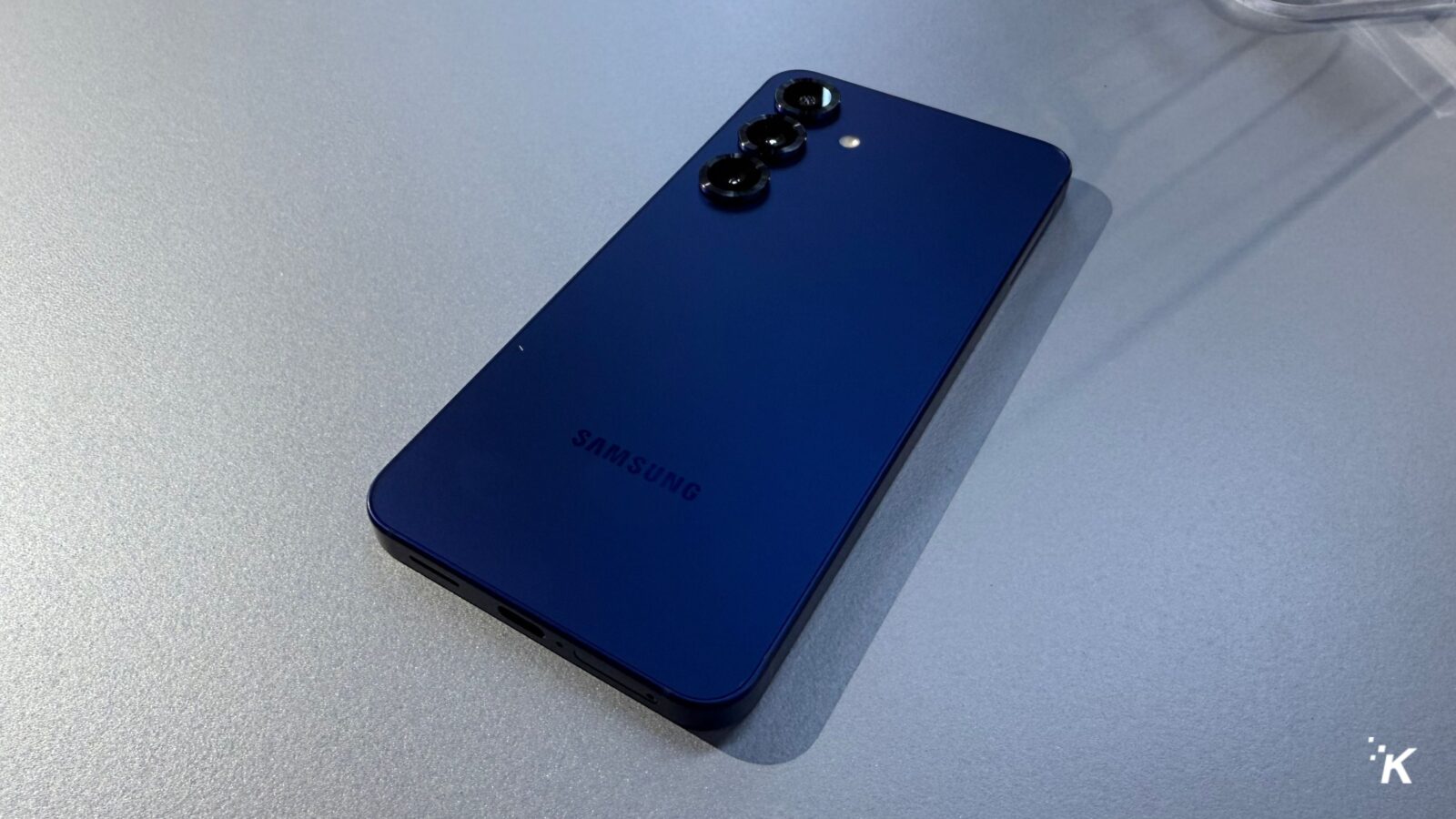 Smartphone Samsung azul em uma superfície cinza