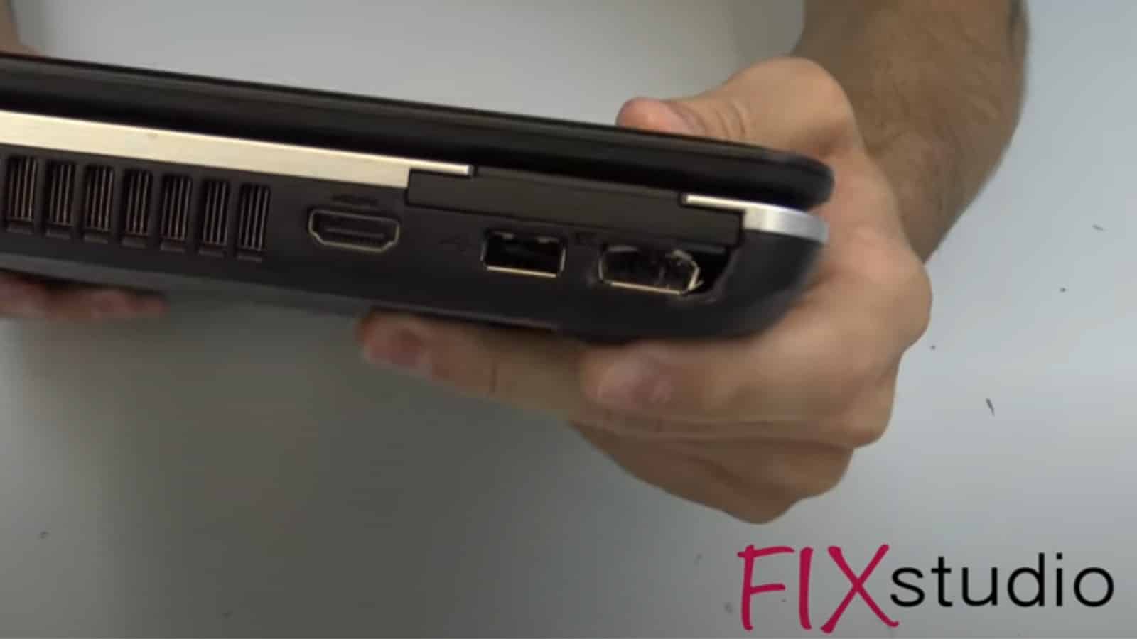 perfil lateral de una computadora portátil con un puerto usb visiblemente roto