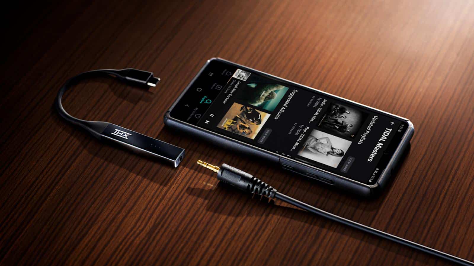 thx onyx dac amp di atas meja di sebelah smartphone dan colokan headphone