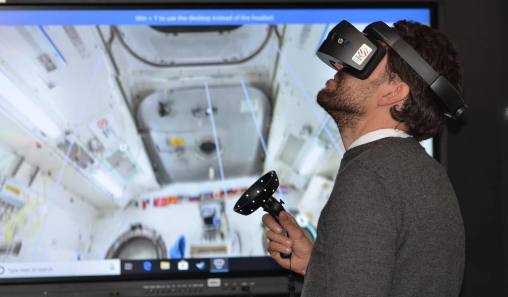 hombre usando auriculares vr para explorar una nave espacial