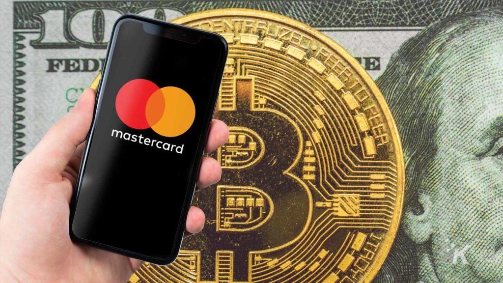 背後に暗号通貨があるスマートフォンのマスターカード