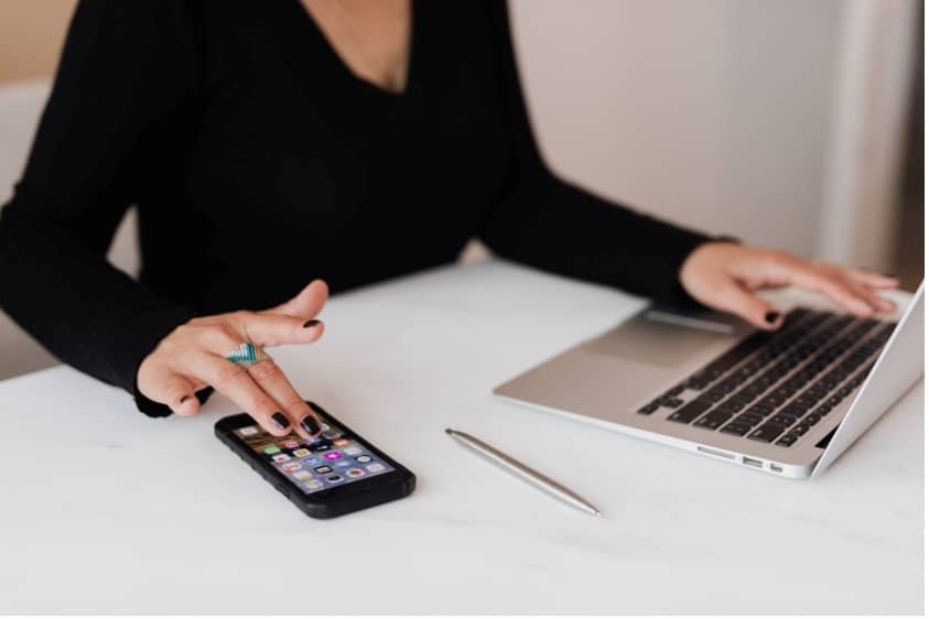 A person with a phone and a laptop.